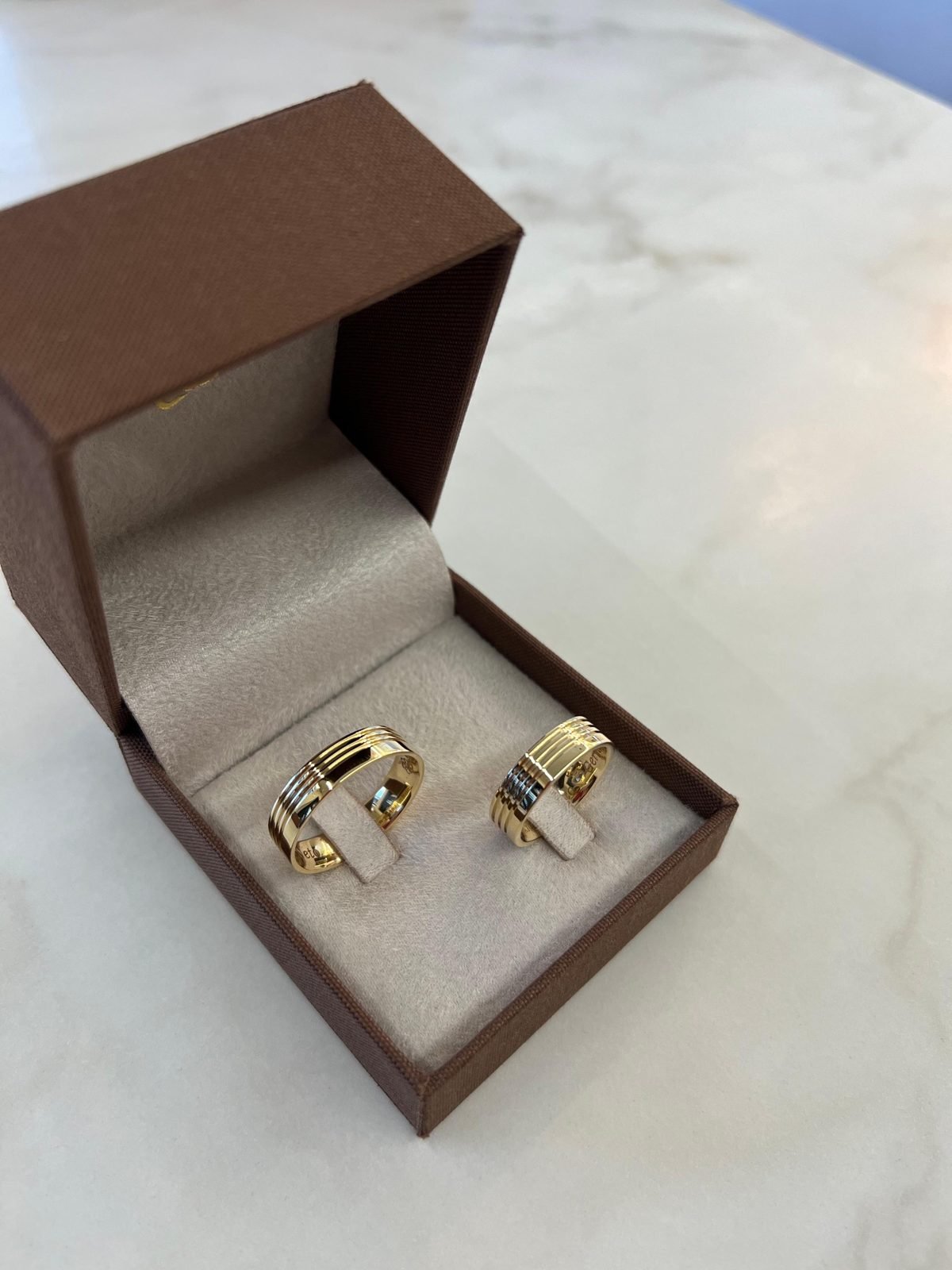 Alianças com frisos trabalhados em ouro 18K