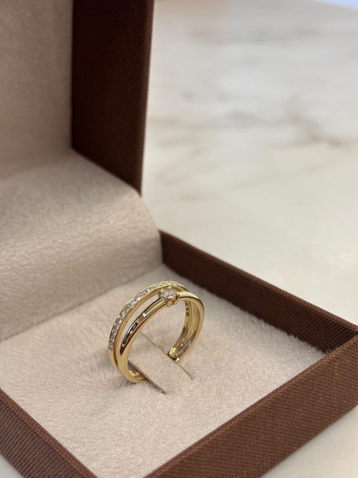 Anel duplo com solitário e aro cravejado em ouro amarelo